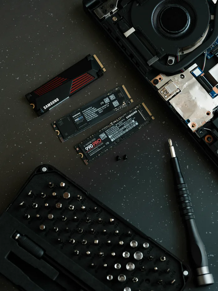 Samsung NVMe SSDs and laptop disassembly tools on a workbench during SSD data recovery